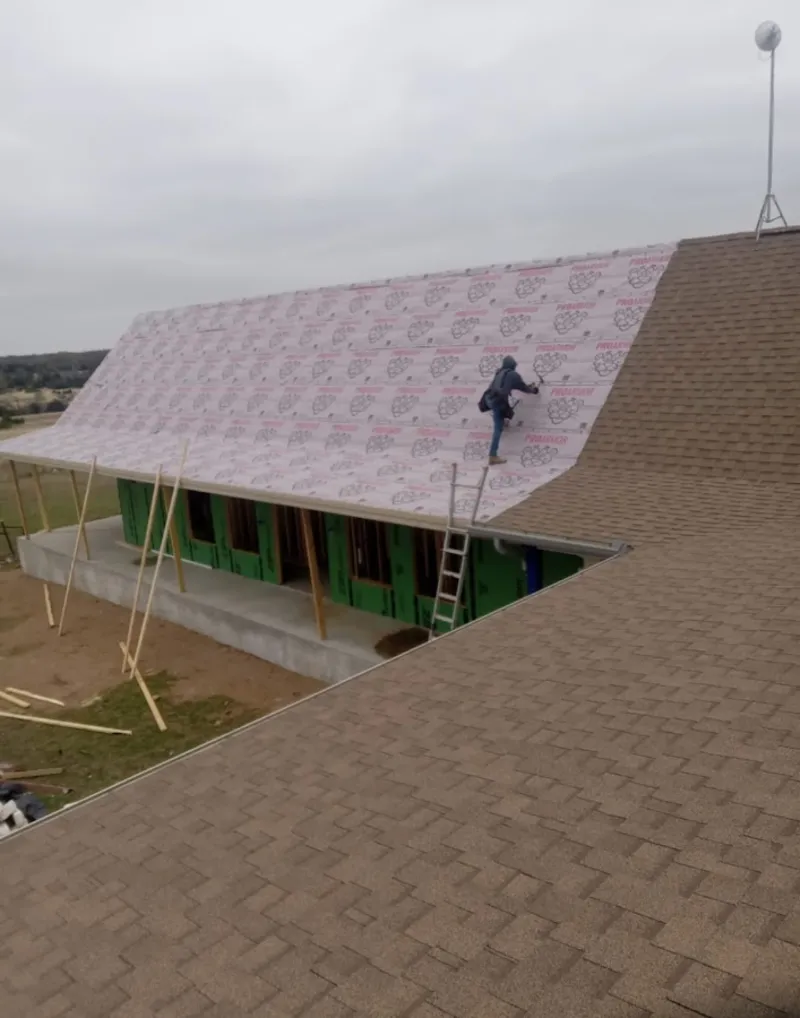 Worker preparing underlayment for a metal roof installation in Bloomingdale